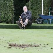 Picking up the pieces: Nigel Juniper upset by vandalism at Braintree Sports Club, pictured by the damaged bowls green.