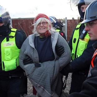 A protester is led away by police officers at Dale Farm near Basildon, Essex, on the second day of the eviction of the traveller site
