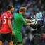 Manchester City goalkeeper Joe Hart holds back Matthew Stott as he goes towards Manchester United's Rio Ferdinand