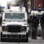 Police in riot gear approach loyalist protesters who converged outside Belfast City Hall.