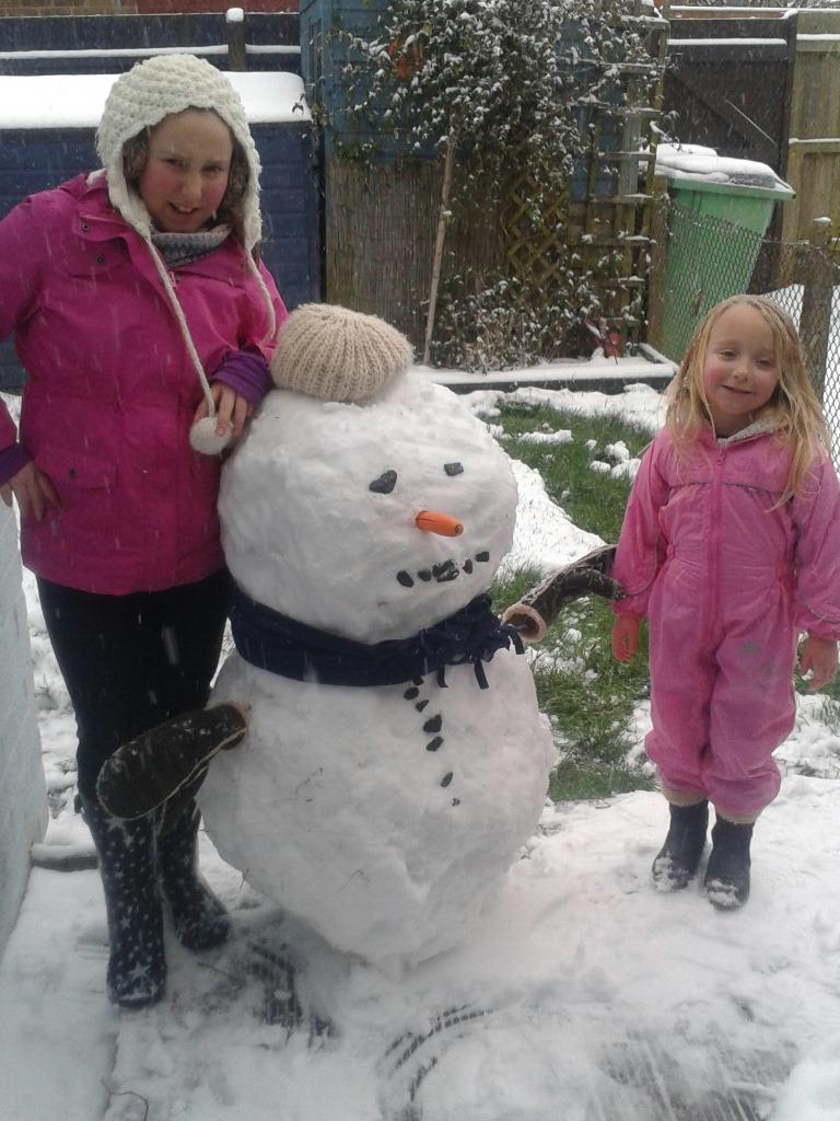 Dharma and Grace Cole with the snowman in Witham