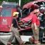 Firefighters walk by the damaged truck