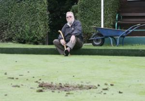 Picking up the pieces: Nigel Juniper upset by vandalism at Braintree Sports Club, pictured by the damaged bowls green.