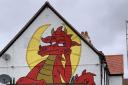 CAUSING A FLAP: New pub owner Ben Davies (right) with dad Dave and the Drunken Dragon mural Picture: Dave Davies