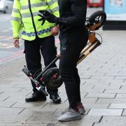 An e-scooter rider is stopped by a police officer