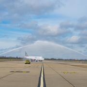 A water arch by the airport's first service welcomes the first flight's arrival